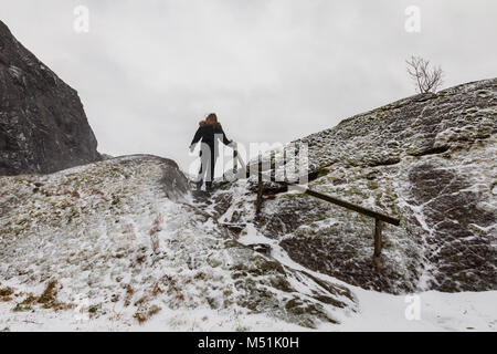 Femme de marcher seul, l'ascension d'une montagne par temps de neige. Banque D'Images