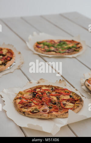 De délicieuses pizzas italiennes servi sur table en bois blanc Banque D'Images