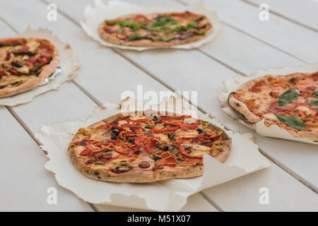 De délicieuses pizzas italiennes servi sur table en bois blanc Banque D'Images