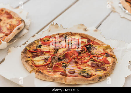 De délicieuses pizzas italiennes servi sur table en bois blanc Banque D'Images