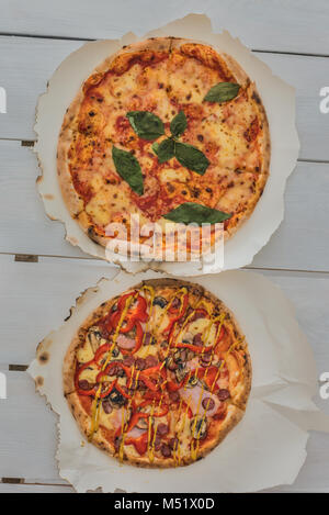 De délicieuses pizzas italiennes servi sur table en bois blanc Banque D'Images