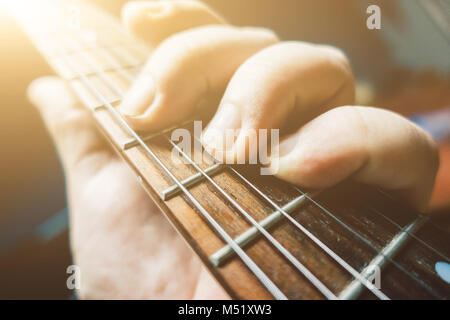 Jeune homme part jouer à la guitare. Close-up shot. Banque D'Images