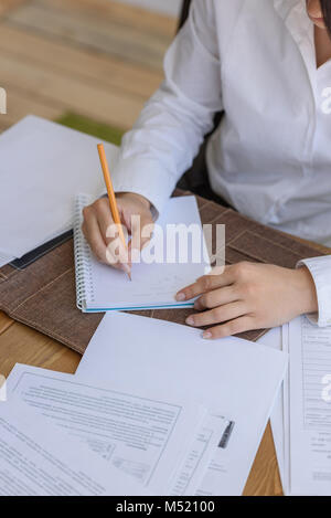 Femme écrit à l'office au cours de la journée de travail Banque D'Images