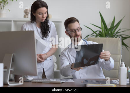 Doctors discussing intestins xray at medical office Banque D'Images