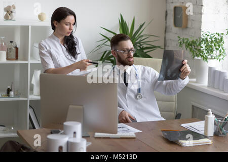 Doctors discussing intestins xray at medical office Banque D'Images