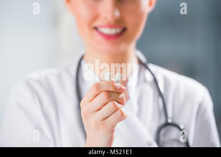 Jeune femme médecin dentiste holding chewing-gum et souriant. Concept d'hygiène buccale Banque D'Images