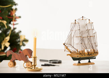 Vintage cheval de bois et d'expédier sur Santa's table de travail, sur fond d'arbre de Noël Banque D'Images