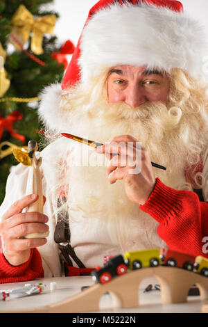 Le Père Noël dans son atelier faire de nouveaux jouets pour des cadeaux de Noël pour les enfants dans le monde Banque D'Images