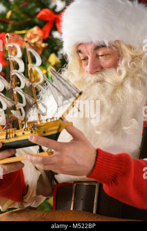 Le Père Noël dans son atelier faire de nouveaux jouets pour des cadeaux de Noël pour les enfants dans le monde Banque D'Images