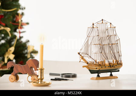 Vintage cheval de bois et d'expédier sur Santa's table de travail, sur fond d'arbre de Noël Banque D'Images