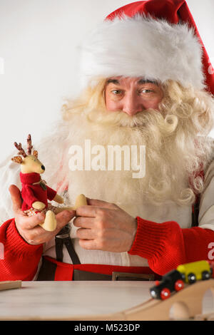 Le Père Noël dans son atelier faire de nouveaux jouets pour des cadeaux de Noël pour les enfants dans le monde Banque D'Images