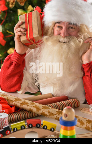 Le Père Noël dans son atelier faire de nouveaux jouets pour des cadeaux de Noël pour les enfants dans le monde Banque D'Images