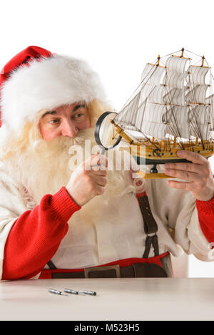 Le Père Noël dans son atelier faire de nouveaux jouets pour des cadeaux de Noël pour les enfants dans le monde Banque D'Images