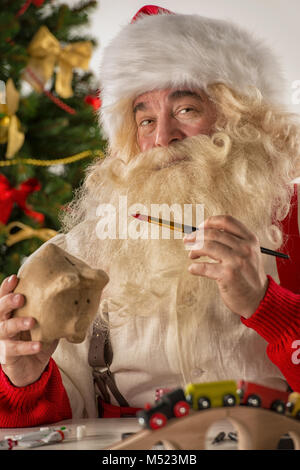 Le Père Noël dans son atelier faire de nouveaux jouets pour des cadeaux de Noël pour les enfants dans le monde Banque D'Images