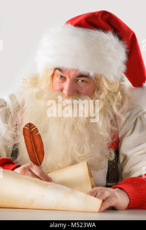 Vrai Père Noël écrit Liste de cadeaux ou de répondre aux lettres d'enfants sur vieux papier faites défiler, isolé sur fond blanc Banque D'Images