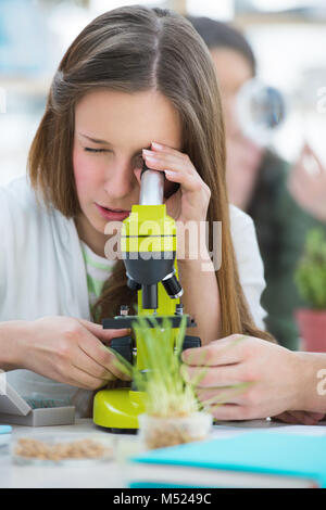 Les élèves du secondaire. Belle jeune fille travaillant à classe de biologie microscope : Banque D'Images