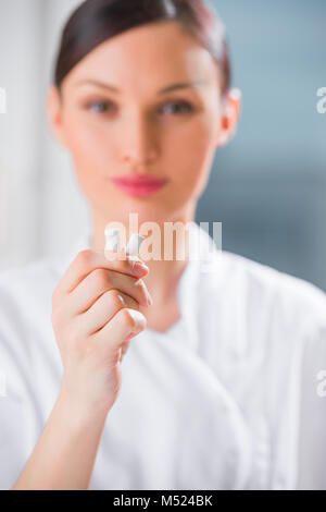 Jeune femme médecin dentiste holding chewing-gum et souriant. Concept d'hygiène buccale Banque D'Images