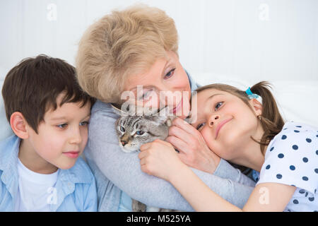 Portrait of smiling grandfather hugging on sofa avec Granny's Cat Banque D'Images