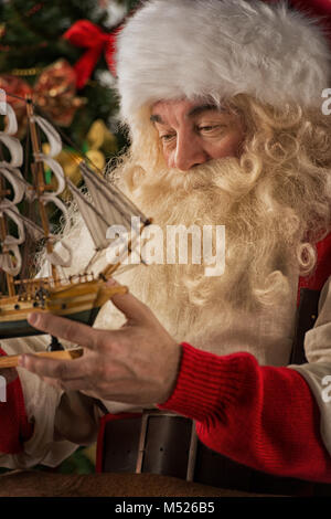 Le Père Noël dans son atelier faire de nouveaux jouets pour des cadeaux de Noël pour les enfants dans le monde Banque D'Images