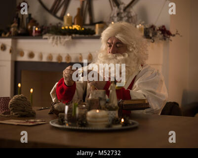 Travailler à la maison du Père Noël. La réparation de ses gants Banque D'Images