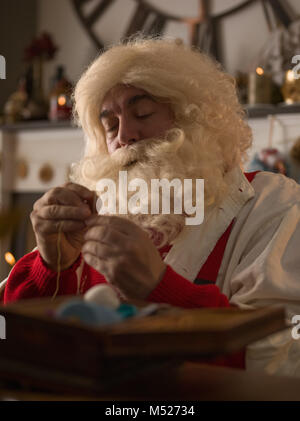 Travailler à la maison du Père Noël. La réparation de ses gants Banque D'Images