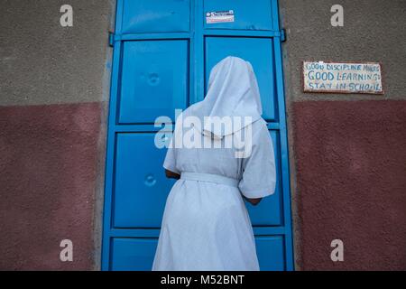 Une religieuse ouvre la porte au dortoir des filles à l'école primaire, Kalas Amudat, District de Karamoja, en Ouganda, où quelques filles pour échapper à l'excision et le mariage des enfants. Les mutilations génitales féminines (MGF) a été déclaré illégal en Ouganda depuis 2010, mais les travailleurs de l'aide et la police dit que c'est encore pratiquée par les tribus dans le nord-est, y compris les Pokots, Sebei, Tepeth et Kadama. Banque D'Images