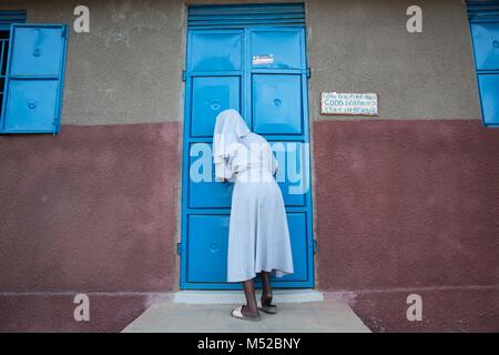 Une religieuse ouvre la porte au dortoir des filles à l'école primaire, Kalas Amudat, District de Karamoja, en Ouganda, où quelques filles pour échapper à l'excision et le mariage des enfants. Les mutilations génitales féminines (MGF) a été déclaré illégal en Ouganda depuis 2010, mais les travailleurs de l'aide et la police dit que c'est encore pratiquée par les tribus dans le nord-est, y compris les Pokots, Sebei, Tepeth et Kadama. Banque D'Images