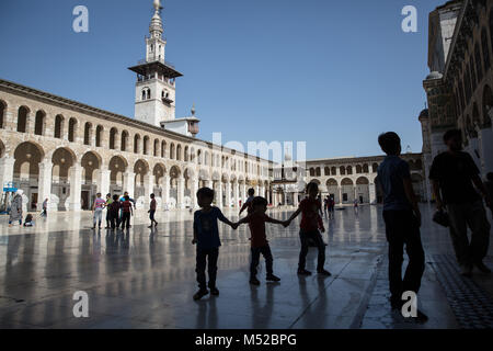 Les enfants jouent dans la mosquée des Omeyyades de Damas au cours de la prière du vendredi. Malgré le conflit en cours en Syrie, dans la vie des pièces détenues par le gouvernement de Damas porte toujours sur relativement pacifiquement. Damas, la capitale de la Syrie, est le plus souvent sous contrôle officiel par le gouvernement syrien du président Bachar al-Assad. Banque D'Images