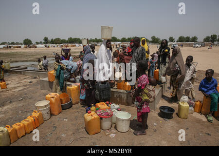 Les personnes déplacées se réunissent pour recueillir l'eau dans un camp de personnes déplacées à la périphérie de Maiduguri. Banque D'Images