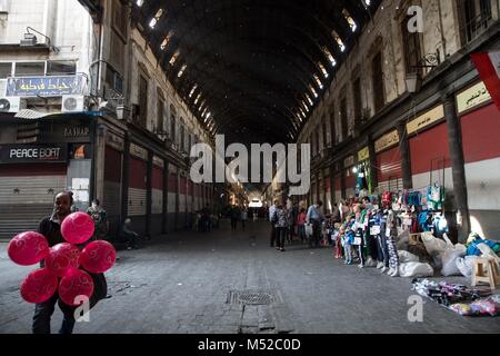 Un homme vend des ballons dans l'Al-Hamidiyah Souq, dans la vieille ville de Damas. Malgré le conflit en cours en Syrie, dans la vie des pièces détenues par le gouvernement de Damas porte toujours sur relativement pacifiquement. Damas, la capitale de la Syrie, est le plus souvent sous contrôle officiel par le gouvernement syrien du président Bachar al-Assad. Banque D'Images