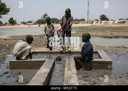 Les enfants jouent dans l'eau dans le camp de personnes déplacées de Garage Muna. Plus de deux millions ont été déplacés pendant le conflit avec Boko Haram. Banque D'Images