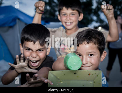 Les enfants posant pour la photo à EKO Camp de réfugiés dans le Nord de la Grèce. Des dizaines de milliers de réfugiés sont bloqués en Grèce comme beaucoup de nations de l'UE a fermé leurs frontières pour empêcher les réfugiés des inondations sur leurs territoires. Banque D'Images