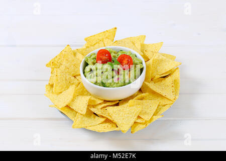 Bol de guacamole avec des chips tortilla Maïs sur fond blanc Banque D'Images