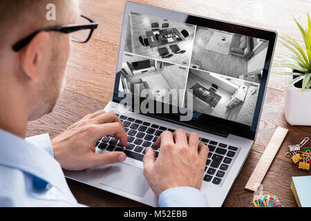 Portrait d'un homme noir et blanc de surveillance vidéo avec sur l'ordinateur portable à la maison Banque D'Images