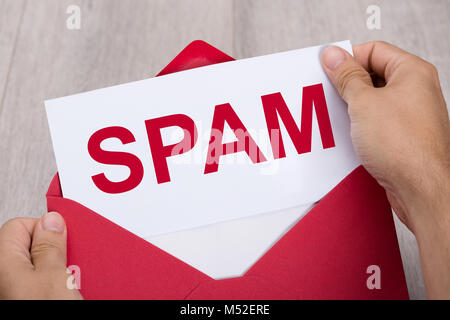 Close-up of a person's Hand Holding Red enveloppe Avec Spam Document texte Banque D'Images