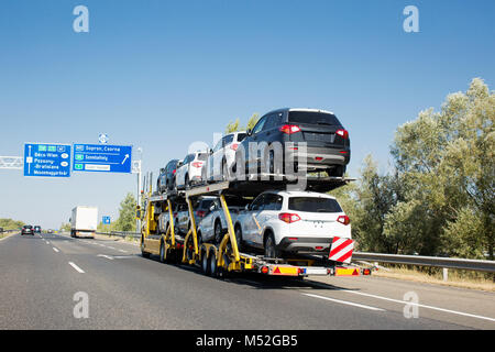 Grande voiture avec remorque porte-voitures neuves en vente sur la plate-forme superposés. Transport de voiture camion sur l'autoroute Banque D'Images