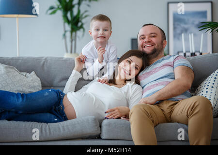 Photo de heureux parents avec de petits fils sur canapé Banque D'Images