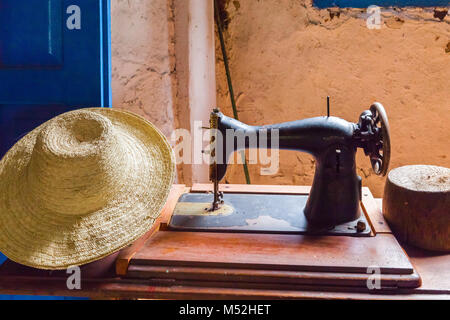 Vieille machine à coudre et chapeau de paille en grand-mère prix Banque D'Images