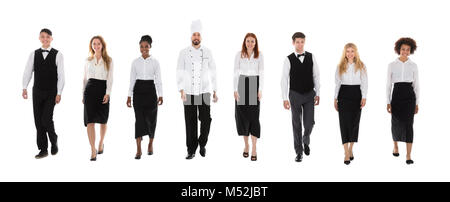 Équipe de Professionnels Personnel de restaurant en uniforme marchant sur fond blanc Banque D'Images