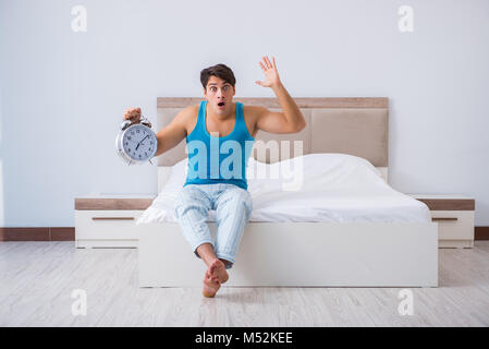 Jeune homme Waking up in bed Banque D'Images