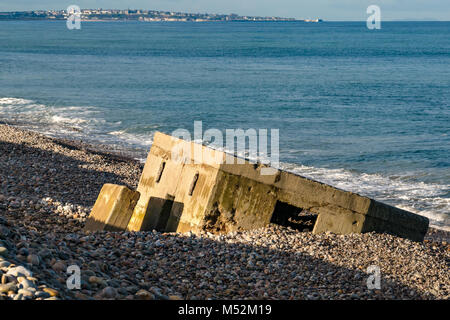 La défense de la Seconde Guerre mondiale bunker en béton coulé en galets, Spey Bay, Moray, Écosse, Royaume-Uni, Lossiemouth in distance Banque D'Images