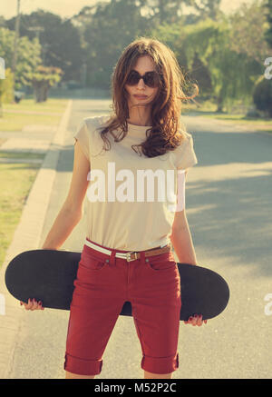 Belle jeune fille avec skateboard Banque D'Images