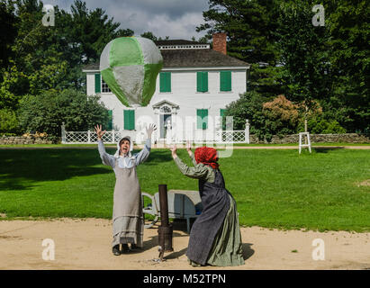 Deux femmes, en costume à Old Sturbridge Village, remplir un ballon à air chaud maison dans une démonstration des jouets anciens. Banque D'Images