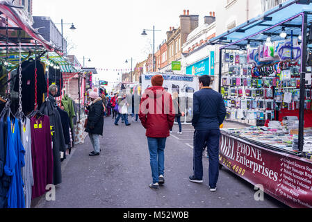 Personnes à pied et shopping autour de plusieurs échoppes à la chapelle, une rue du Marché quotidien du marché dans Angel, Islington, Londres, Royaume-Uni. Banque D'Images