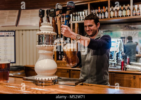 Pichet de bière barman remplit au robinet gare bien approvisionné avec une variété de Samuel Adams. La célèbre brasserie avec une longue histoire attire les loc Banque D'Images