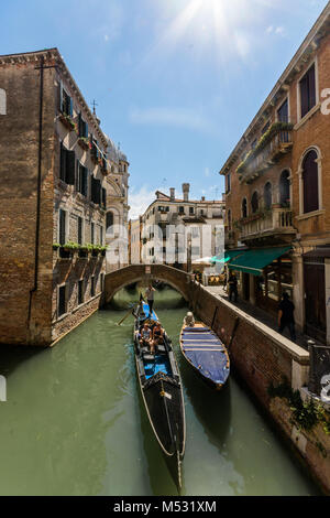 La belle ville d'itinéraires vénitiens du canal et des promenades en gondole, le soleil flair dans le coin avec les bâtiments de la vieille ville en face. Banque D'Images