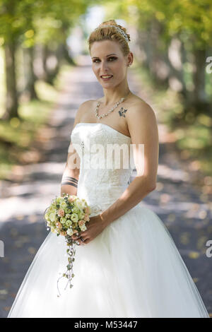 Jeune femme blonde à la robe de mariée blanche Banque D'Images