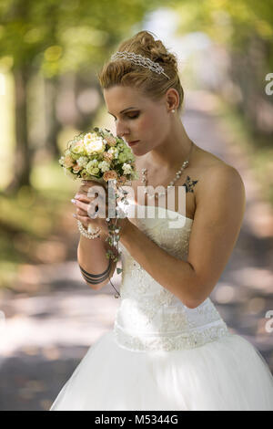 Jeune femme blonde à la robe de mariée blanche Banque D'Images
