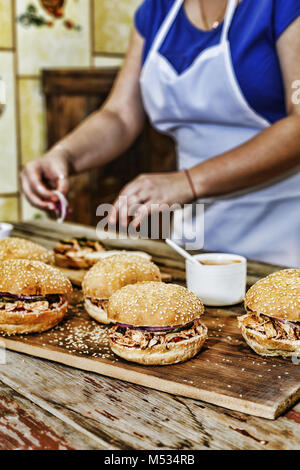 La cuisine maison. Une femme est la cuisson des hamburgers Banque D'Images