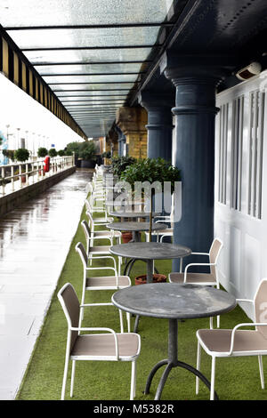 Une ligne ou une ligne de tables et chaises sur la rive de la Tamise dans le centre de Londres à l'extérieur d'un restaurant ou un café pour dîner en plein air dans la ville. Banque D'Images